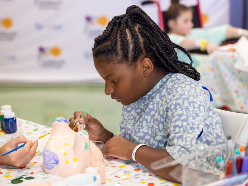Children's of Mississippi patient Kirsten Johnson of Madison paints a chicken tee marker for the Sanderson Farms Championship. Jay Ferchaud/ UMMC Photography